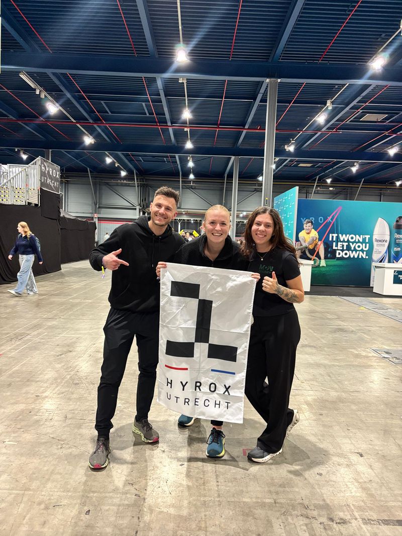 Atleten van Momentom met de Hyrox Utrecht vlag na hun race